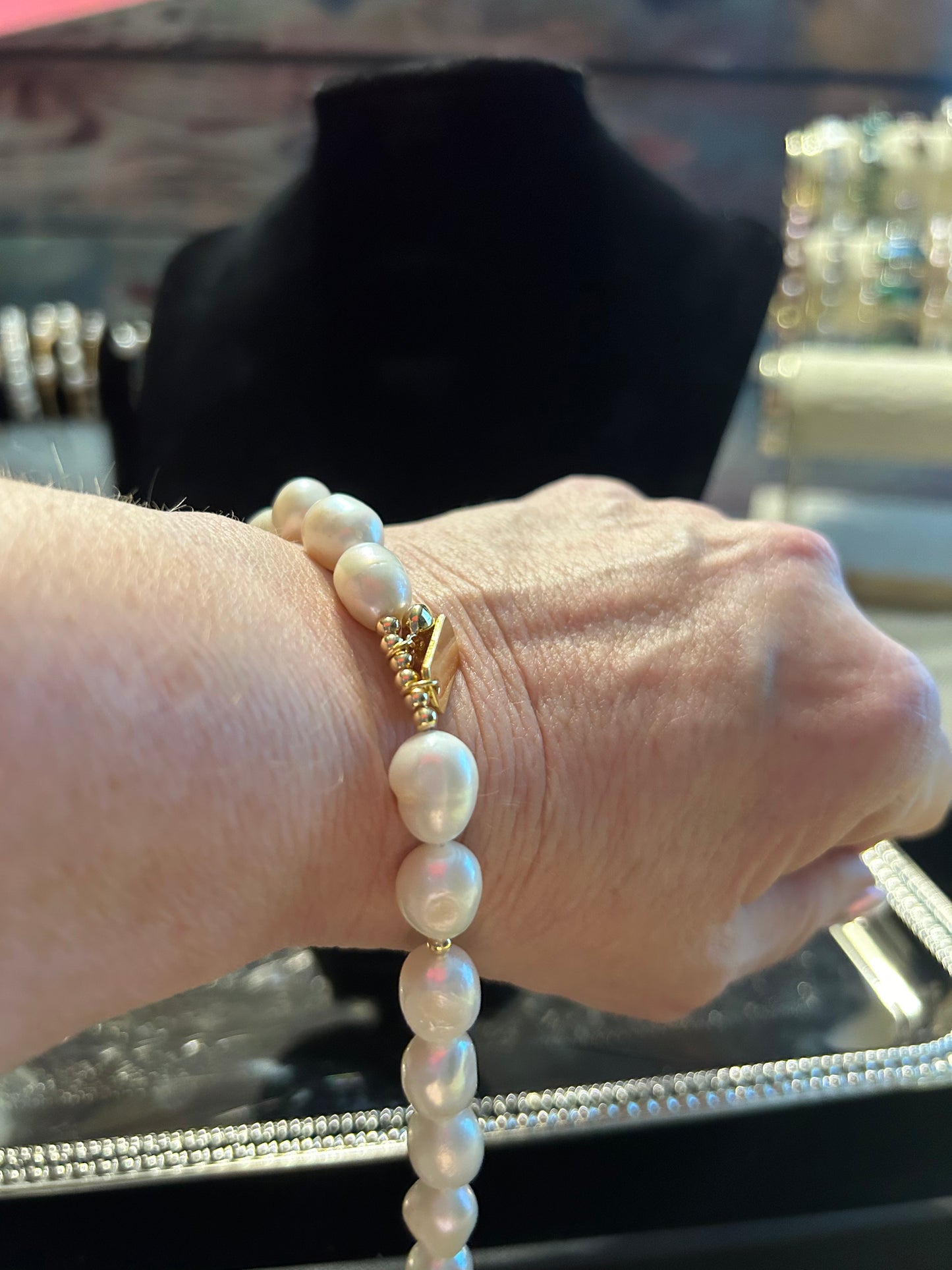 White freshwater pearl bracelet with gold charms